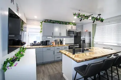 a kitchen with a sink and a counter with chairs at The Wilderness, Near CP & SF, W&D, Pet OK in Sandusky