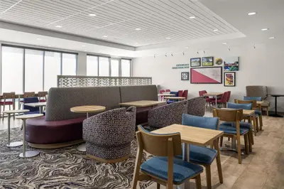 a waiting room with tables and chairs and windows at Home2 Suites By Hilton Dry Ridge in Dry Ridge