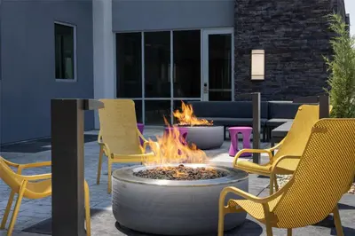 a fire pit in a patio with yellow chairs at Home2 Suites By Hilton Dry Ridge in Dry Ridge