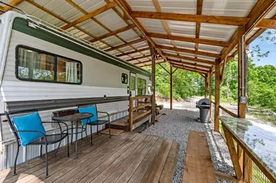 an rv with chairs and a table on a deck at Gorgeous Caravan Glamping Escape for Four in Dover, Ohio in Dover