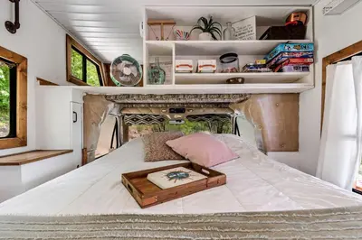 a bed with a wooden tray on top of it at Gorgeous Caravan Glamping Escape for Four in Dover, Ohio in Dover