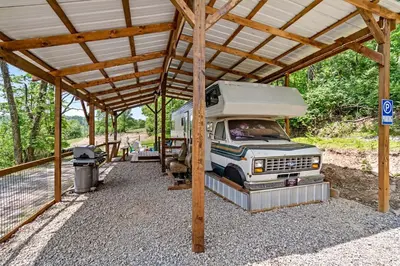 a camper van parked under a wooden structure at Gorgeous Caravan Glamping Escape for Four in Dover, Ohio in Dover