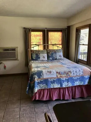 a bedroom with a bed in a room with windows at Cozy Studio Cabin Rental with Hot Tub Perfect for Glamping in Ohio in Logan