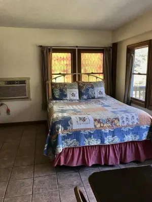 a bedroom with a bed and two windows at Cozy Studio Cabin Rental with Hot Tub Perfect for Glamping in Ohio in Logan