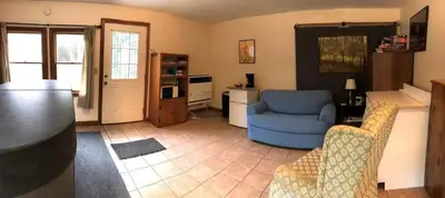 a living room with a couch and a blue chair at Cozy Studio Cabin Rental with Hot Tub Perfect for Glamping in Ohio in Logan