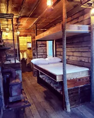 a bedroom with a bed in a log cabin at Rustic Container Accommodation for Glamping in Kentucky in Owenton