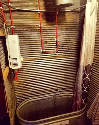 a bathroom with a bath tub and a phone at Rustic Container Accommodation for Glamping in Kentucky in Owenton