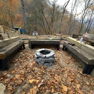 a fire pit in a park with two benches at Remote Mountain A-Frame with BBQ Perfect for Nature Lovers in West Virginia in Charleston