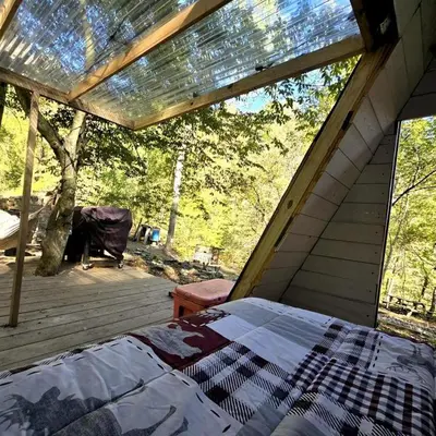a screened in porch with a bed in a room at Remote Mountain A-Frame with BBQ Perfect for Nature Lovers in West Virginia in Charleston
