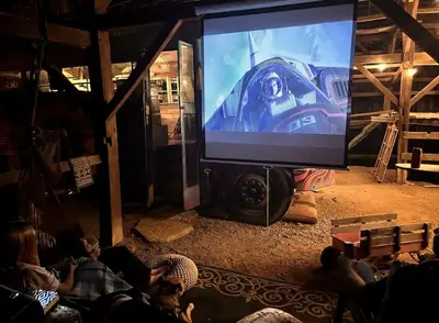 a group of people sitting in front of a large screen at Cozy Hot Tub “Love Bus” near Augusta, Kentucky in Germantown