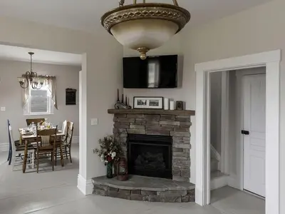 a living room with a stone fireplace and a chandelier at Charming Weekend Getaway Located on a Vineyard near Cleveland, Ohio in Berlin Center