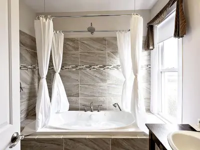 a white bath tub in a bathroom with a window at Charming Weekend Getaway Located on a Vineyard near Cleveland, Ohio in Berlin Center