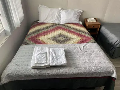 a bed with two white pillows on top of it at The Springs Motel