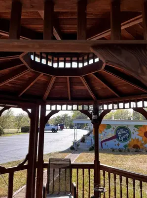 a wooden gazebo with a clock on it at The Springs Motel