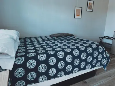 a bedroom with a bed with a black and white comforter at The Springs Motel