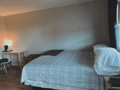 a bedroom with a bed and a table and a desk at The Springs Motel