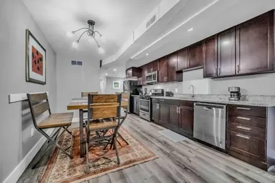 a kitchen with wooden cabinets and a table and chairs at Cle Suites 3BR 2BA 5 min Walk to Cle Clinic Unit 1 in Cleveland