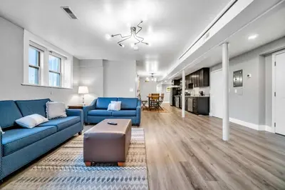 a living room with a blue couch and a table at Cle Suites 3BR 2BA 5 min Walk to Cle Clinic Unit 1 in Cleveland