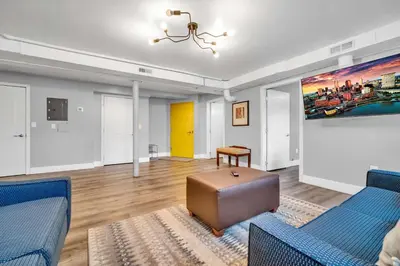 a living room with blue furniture and a painting on the wall at Cle Suites 3BR 2BA 5 min Walk to Cle Clinic Unit 1 in Cleveland