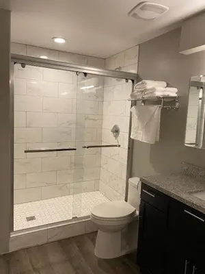 a bathroom with a shower with a toilet and a sink at Cle Suites 3BR 2BA 5 min Walk to Cle Clinic Unit 2 in Cleveland