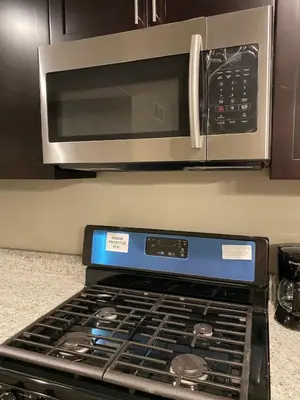 a stove top oven in a kitchen with a microwave at Cle Suites 3BR 2BA 5 min Walk to Cle Clinic Unit 2 in Cleveland
