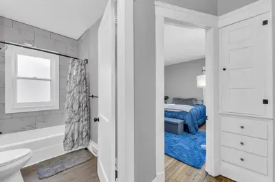 a white bathroom with a tub and a bed at Stylish Retreat by Shaker Square, Fast WiFi, Porch in Cleveland