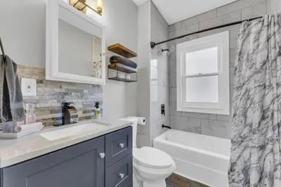 a bathroom with a toilet and a sink and a tub at Stylish Retreat by Shaker Square, Fast WiFi, Porch in Cleveland