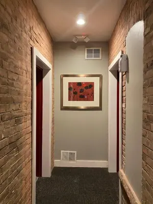 a hallway with a brick wall and a painting on the wall at Cle Suites 2BR 1BA 5 min Walk to Cle Clinic Unit 5 in Cleveland