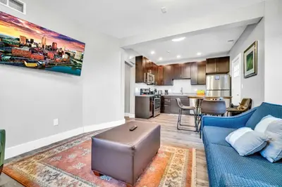 a living room with a blue couch and a kitchen at Cle Suites 1BR 1BA 5 min Walk to Cle Clinic Unit 6 in Cleveland