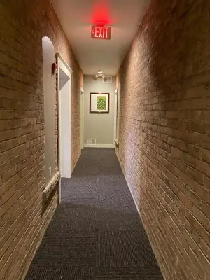a hallway with a exit sign on a brick wall at Cle Suites 1BR 1BA 5 min Walk to Cle Clinic Unit 6 in Cleveland