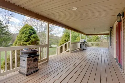 a large wooden porch with a grill on it at Game Room and On-Site Pond Laurelville Retreat! in Laurelville