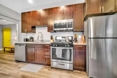 a kitchen with stainless steel appliances and wooden cabinets at Cle Suites 1BR 1BA 5 min Walk to Cle Clinic #7 in Cleveland