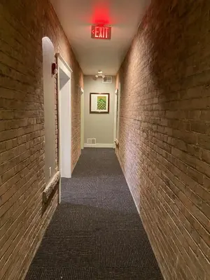 a hallway with a exit sign on a brick wall at Cle Suites 2BR 1BA 5 min Walk to Cle Clinic #8 in Cleveland
