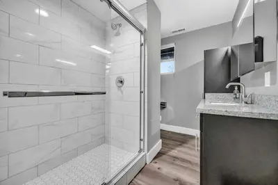 a white bathroom with a shower and a sink at Cle Suites 2BR 1BA 5 min Walk to Cle Clinic #8 in Cleveland