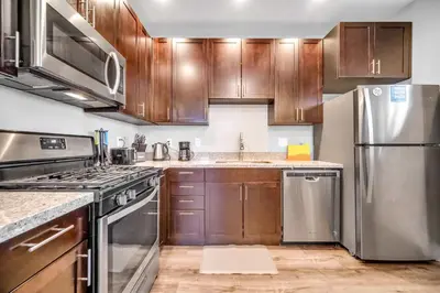 a kitchen with wooden cabinets and stainless steel appliances at Cle Suites 1BR 1BA 5 min Walk to Cle Clinic #10 in Cleveland