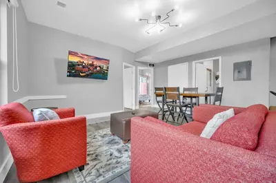 a living room with two red chairs and a table at Cle Suites 2BR 1BA 5 min Walk to Cle Clinic #9 in Cleveland