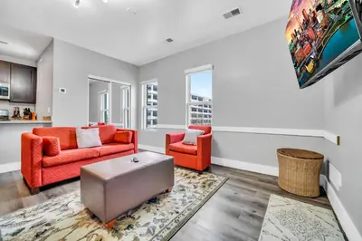 a living room with two orange chairs and a rug at Cle Suites 2BR 1BA 5 min Walk to Cle Clinic #9 in Cleveland