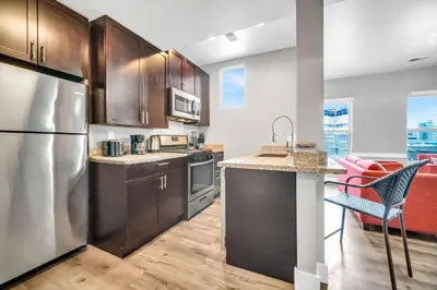 a kitchen with stainless steel appliances and wooden cabinets at Cle Suites 2BR 1BA 5 min Walk to Cle Clinic #9 in Cleveland