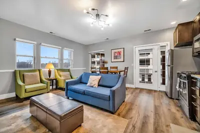 a living room with a blue couch and chairs at Cle Suites 2BR 1BA 5 min Walk to Cle Clinic #12 in Cleveland