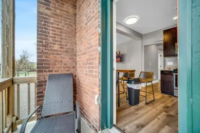 a brick wall next to a balcony with a table and chairs at Cle Suites 1BR 1BA 5 min Walk to Cle Clinic #15 in Cleveland