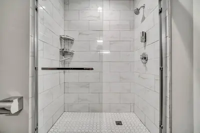 a bathroom with a shower with white tiles at Cle Suites 1BR 1BA 5 min Walk to Cle Clinic #15 in Cleveland