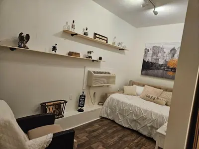 a bedroom with a bed and a couch and shelves at College Park Bungalow in Winchester