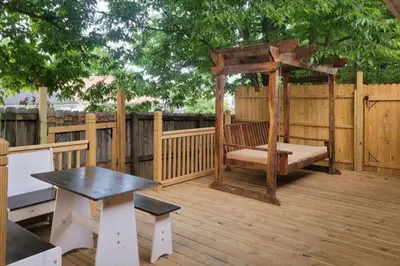 a wooden deck with a bench and a gazebo at College Park Bungalow in Winchester