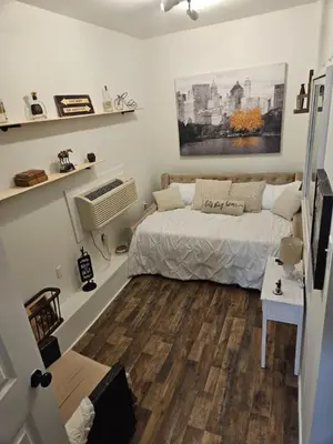a bedroom with a bed and a wooden floor at College Park Bungalow in Winchester