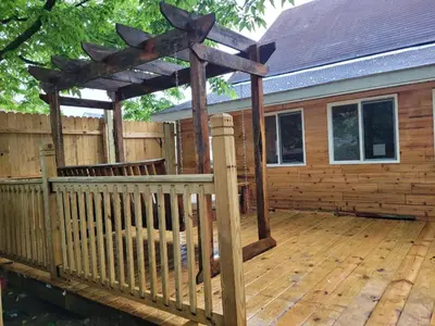 a wooden deck with a pergola on a house at College Park Bungalow in Winchester