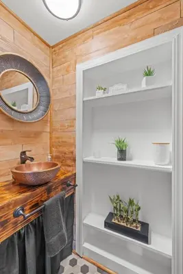 a bathroom with a sink and a wooden wall at College Park Getaway in Winchester