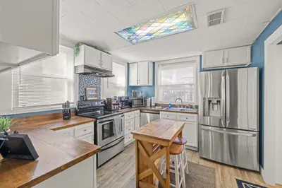 a kitchen with white cabinets and a stainless steel refrigerator at College Park Getaway in Winchester
