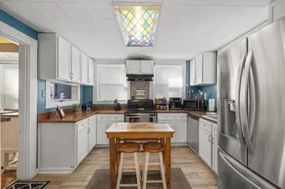 a kitchen with white cabinets and a stainless steel refrigerator at College Park Getaway in Winchester