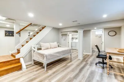 a bedroom with a bed and a staircase at Screened Patio and Fire Pit Modern Westerville Home in Westerville