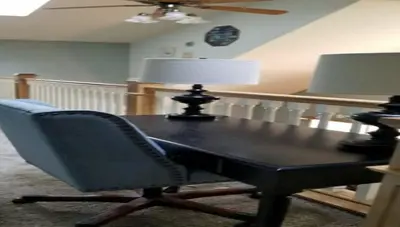 a table with a chair and a lamp on it at Lambs Landing Huron Family Vacation Home in Huron